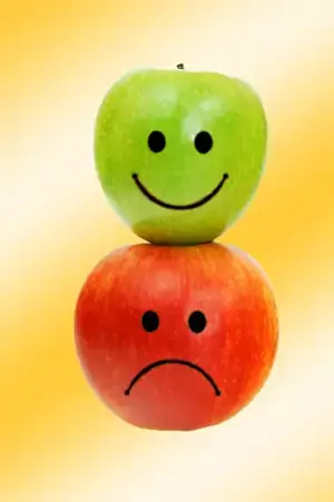 dos manzanas dibujadas en su cara expresiones de Alegría y tristeza 